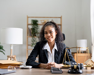 portrait-smiling-female-lawyer-sitting-at-workplac-JL2L95D